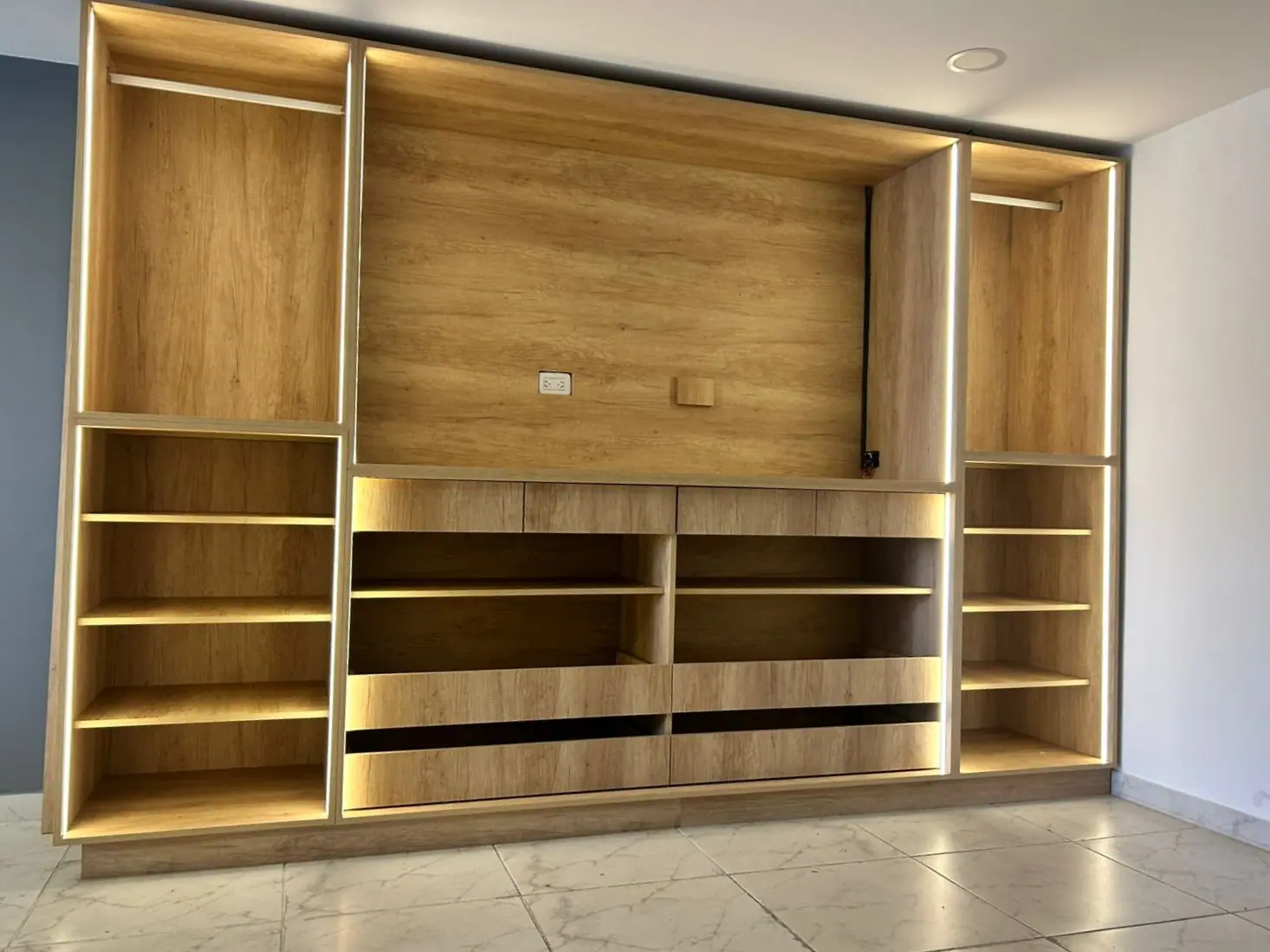 Placard a medida en madera clara con barrales, estantes, cajones e iluminación LED perimetral, fabricado en nuestro taller de Morón