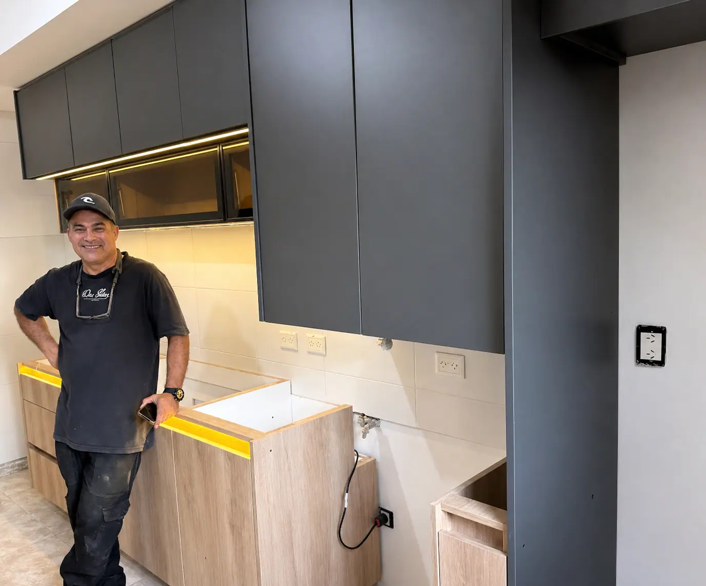 Fundador de Amoblamientos Attianese junto a una cocina a medida durante la instalación